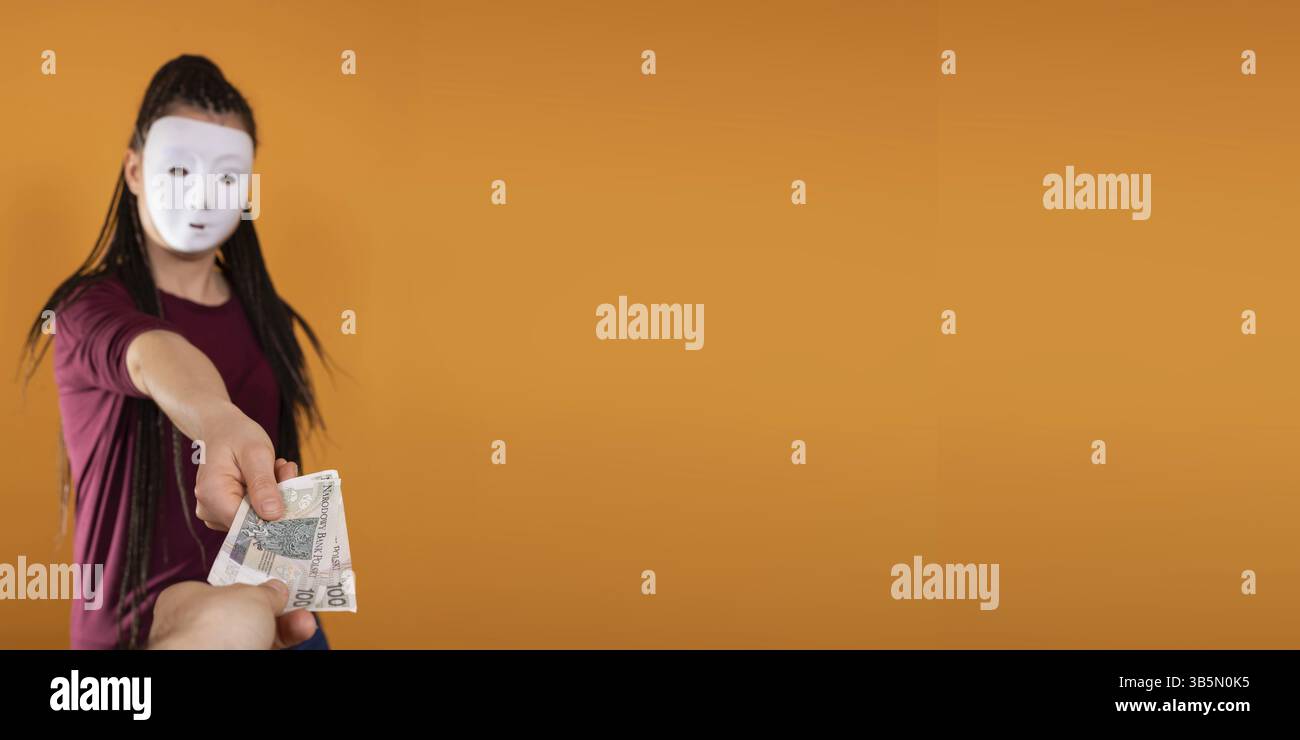In una cornice panoramica, una donna anonima si erge e le disegna in mano con banconote di carta di cento zloty polacchi. Nessuna faccia perché c'è un mas Foto Stock