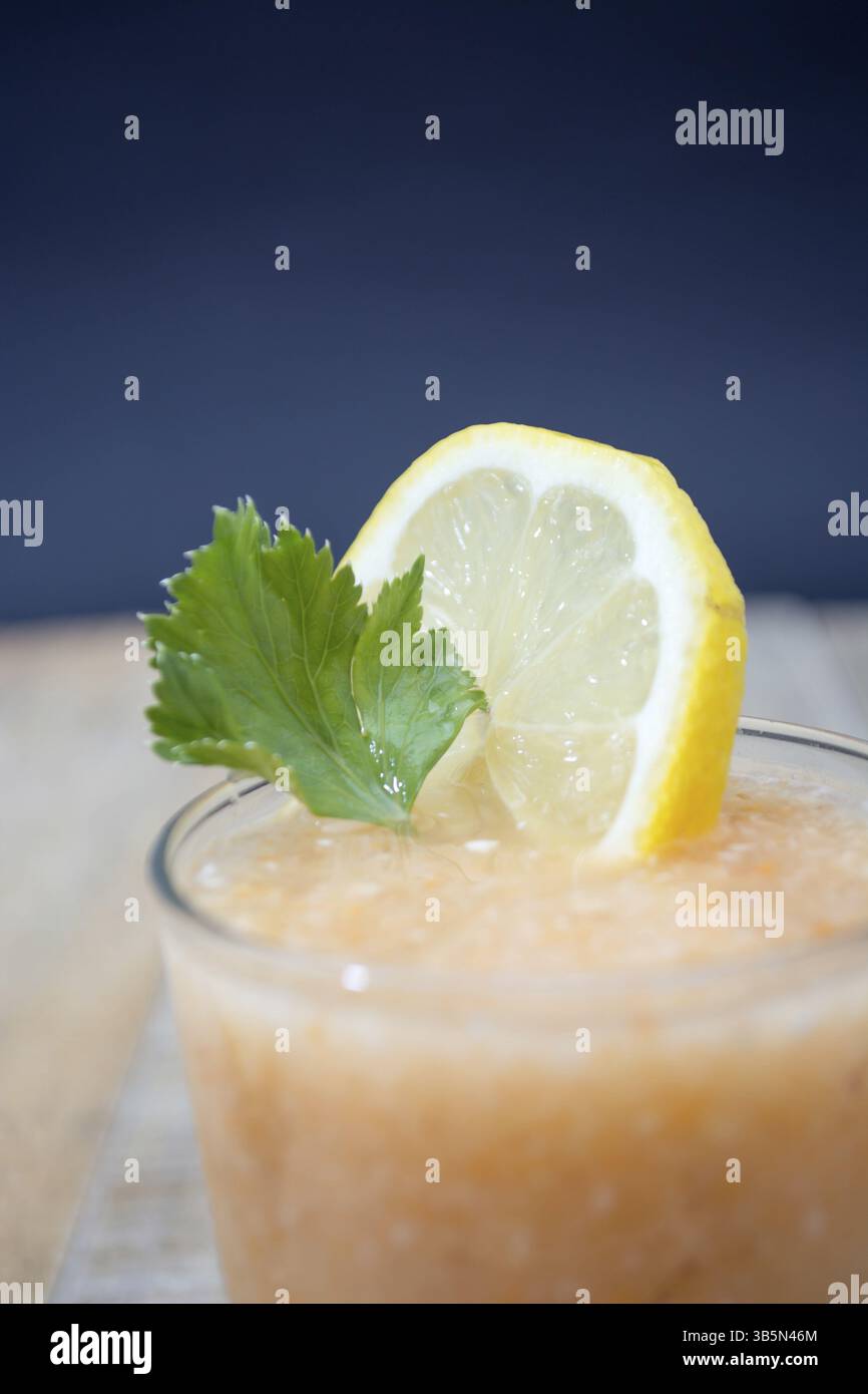Limonata Fresca con zenzero decorato con Verde foglie di sedano e limone su sfondo scuro Foto Stock