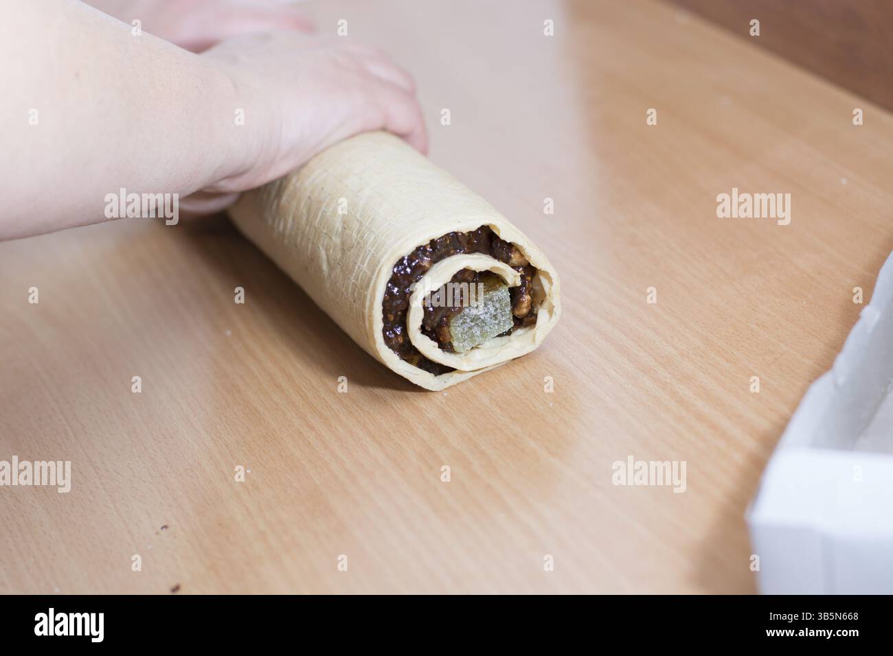 Laminazione crosta torta al cioccolato e caramelle di gelatina. Preparazione per il taglio con il coltello Foto Stock