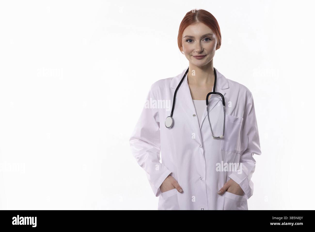 Una donna sicura di sé, che indossa un camice da laboratorio e uno stetoscopio, irradia sicurezza e competenza nel suo campo Foto Stock