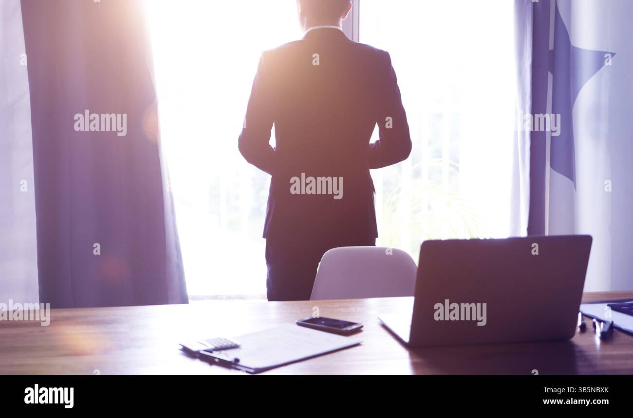 Vista dall'angolo posteriore dell'uomo d'affari che pensa alla visione del futuro in ufficio Foto Stock