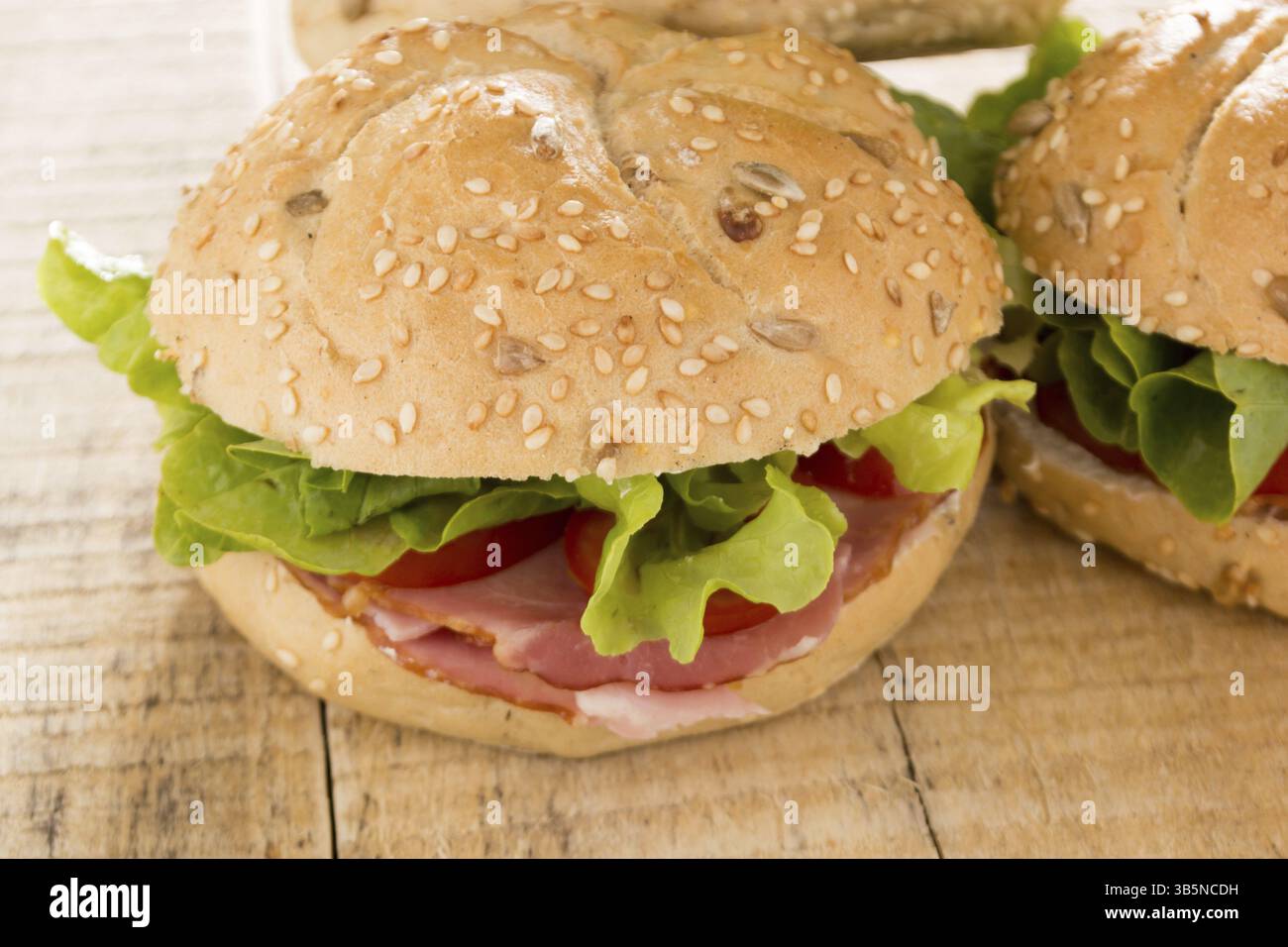 Panini freschi con carne affumicata, formaggio, lattuga e pomodoro con ketchup fatti in casa Foto Stock