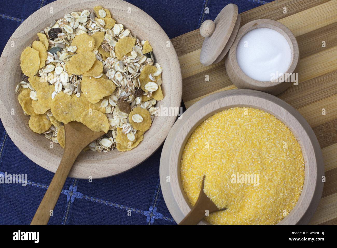 Sale in una piccola ciotola di legno posto sul piatto di legno con i cereali e la farina di mais Foto Stock