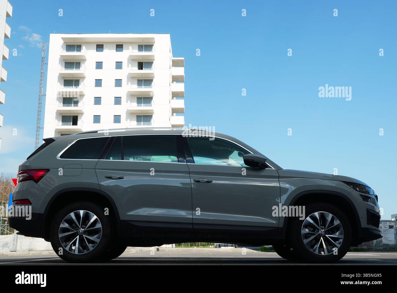 Bucarest, Romania – 21 aprile 2025: Vista laterale dell'auto SUV Skoda Kodiaq sul parcheggio con blocco di appartamenti in costruzione dietro Foto Stock
