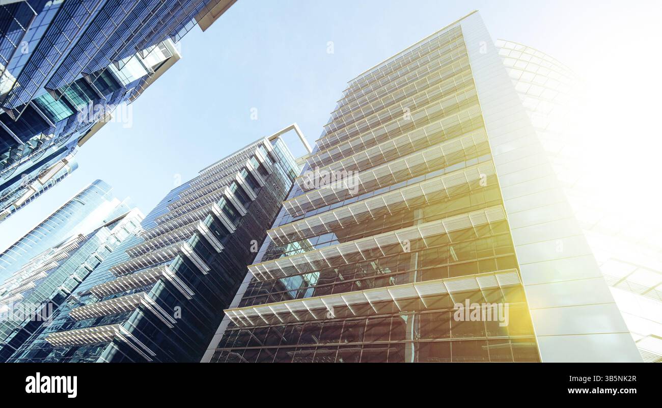 Moderni grattacieli, edifici alti, architettura che si innalza verso il cielo, il sole. Concetti di finanza, economia, futuro, ecc. Foto Stock