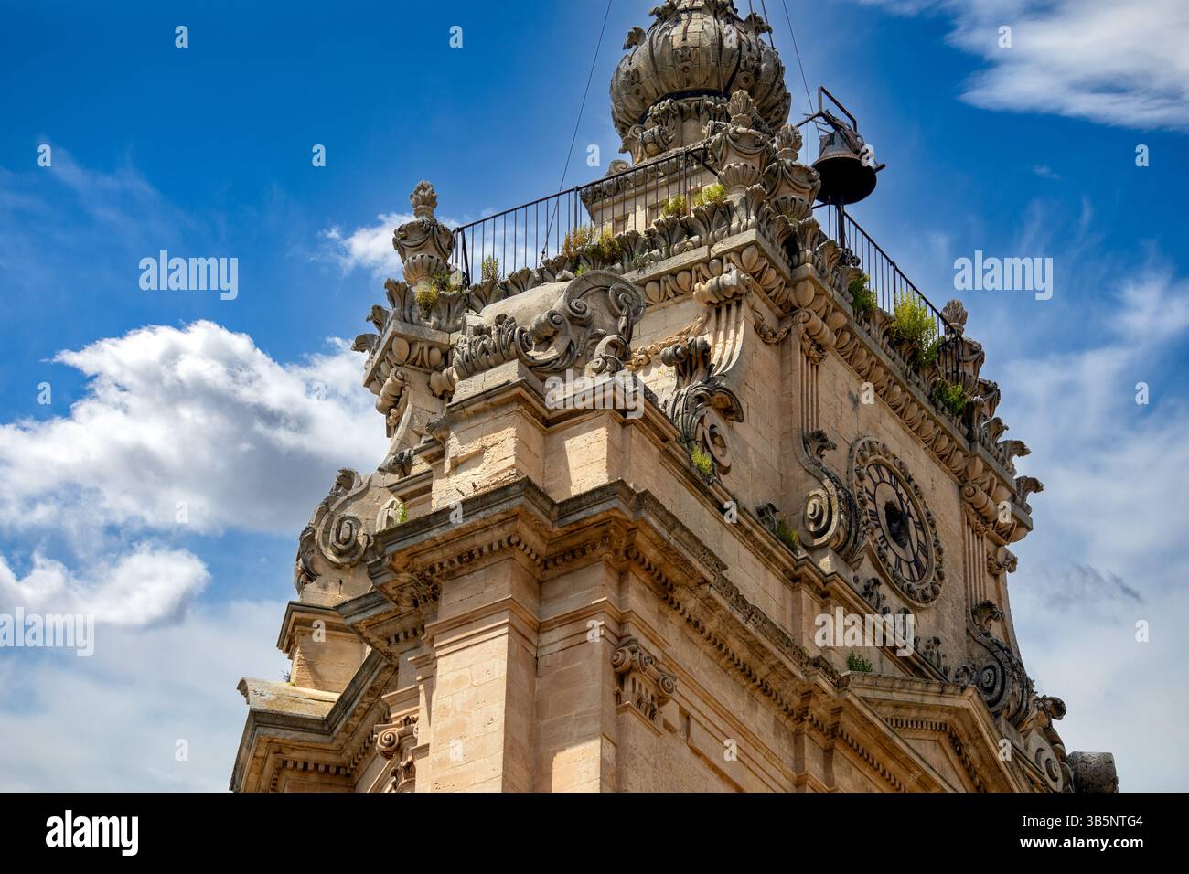Dettaglio del campanile barocco della Cattedrale di San Giorgio a Modica, Sicilia, Italia, con cielo azzurro e nuvole Foto Stock