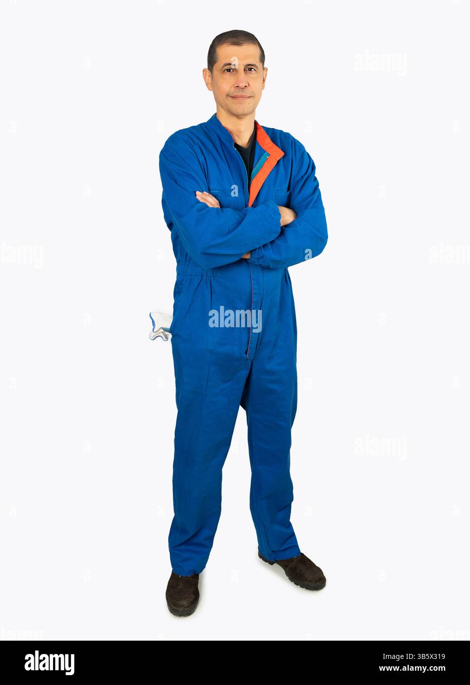 Ritratto a tutta lunghezza di un lavoratore maschile in un'uniforme generale che posa e sorride isolato su sfondo bianco Foto Stock