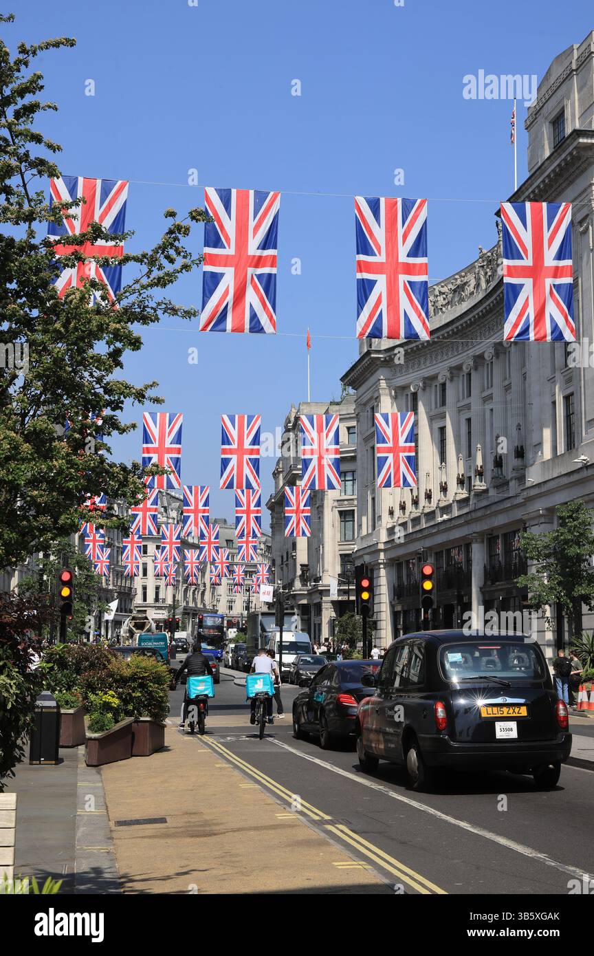 Union Jacks sorvolando Regents e Oxford Street per commemorare la commemorazione di quest'anno del VE Day nel centro di Londra, Regno Unito Foto Stock