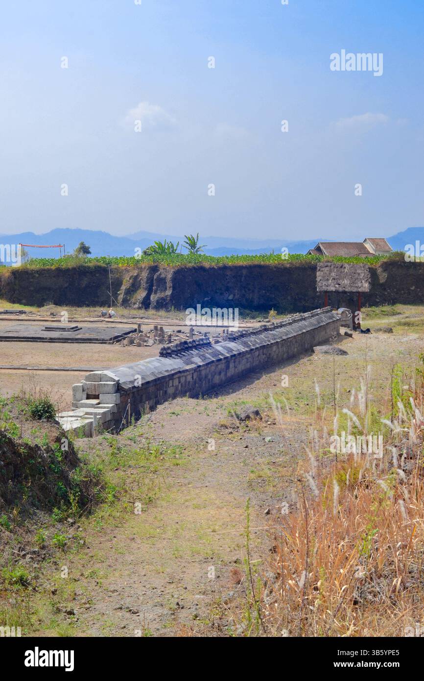 Antico muro Liyangan. Una meraviglia di pietra del IX secolo dall'insediamento indù dimenticato di Giava. Si estende misteriosamente attraverso il suolo vulcanico. Foto Stock