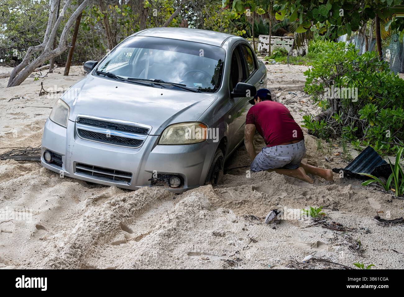 Auto bloccata nella sabbia al faro nella giungla di Punta Allen, Messico, Santana Roo. Il conducente cerca di scavare la nostra macchina. Foto Stock
