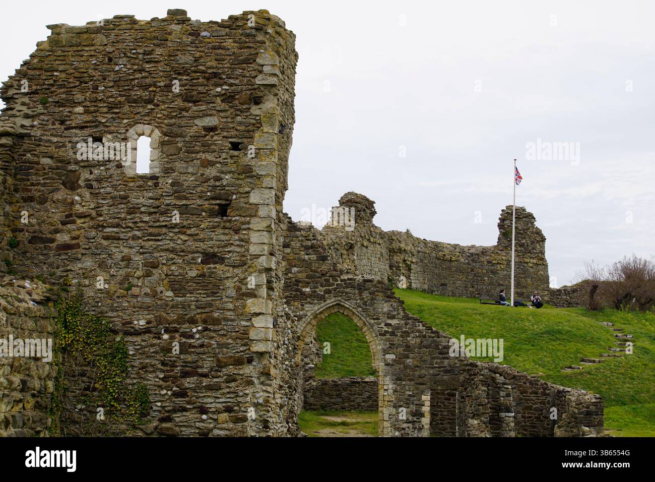Rovine medievali del castello con mura in pietra e archi su una collina erbosa nell'Inghilterra rurale. Hastings, Inghilterra Foto Stock