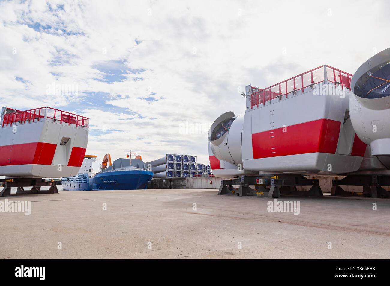 Scarico di parti di turbine eoliche e rotori Vestas nel porto marittimo di Cuxhaven, Germania, da una nave da carico. Foto Stock