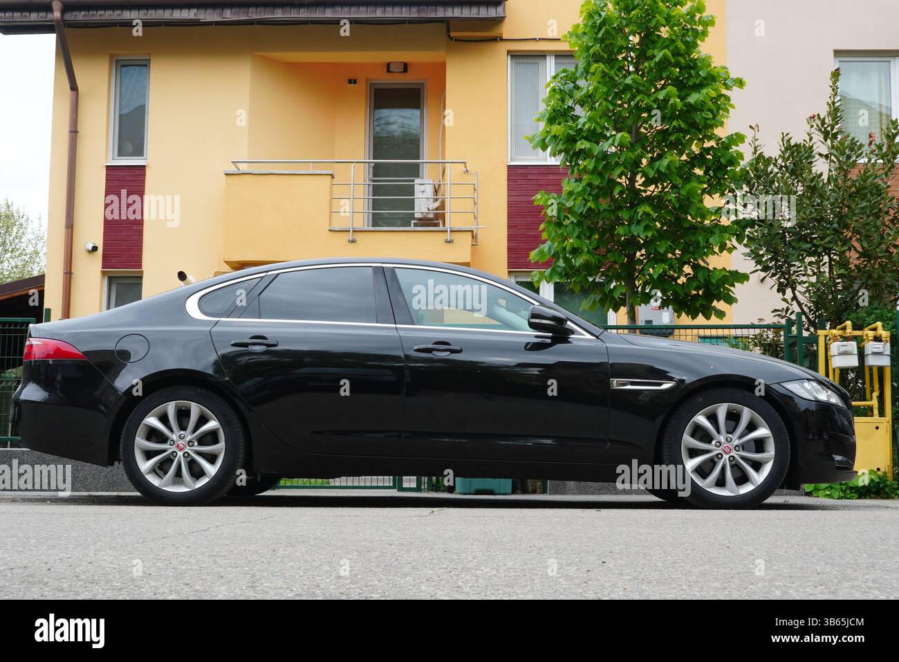 Bucarest, Romania - 27 aprile 2025: Vista laterale dell'elegante Jaguar XF nera davanti a casa Foto Stock