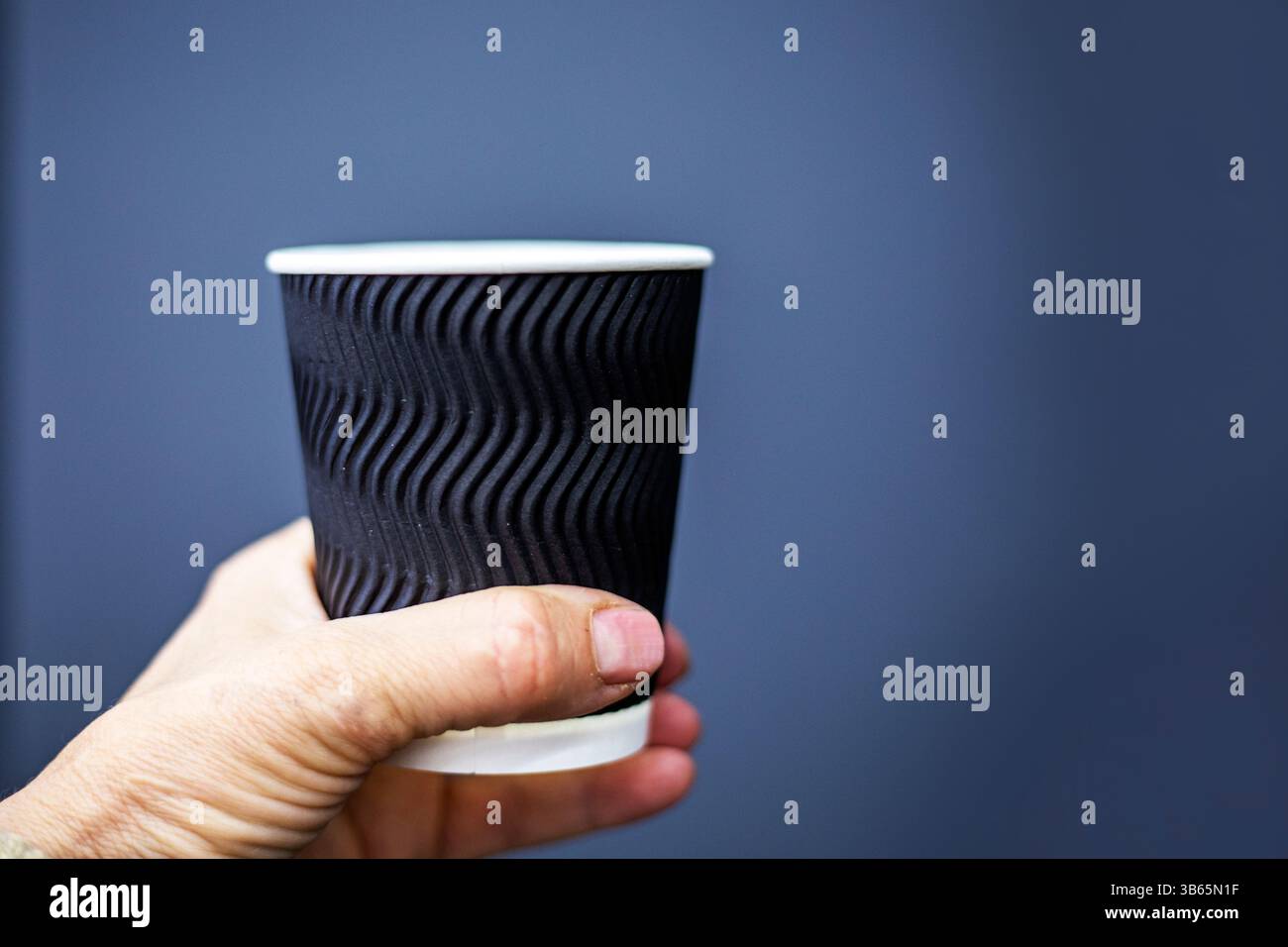 tazza monouso in rilievo nera su sfondo grigio. Mockup per design, loghi, illustrazioni Foto Stock