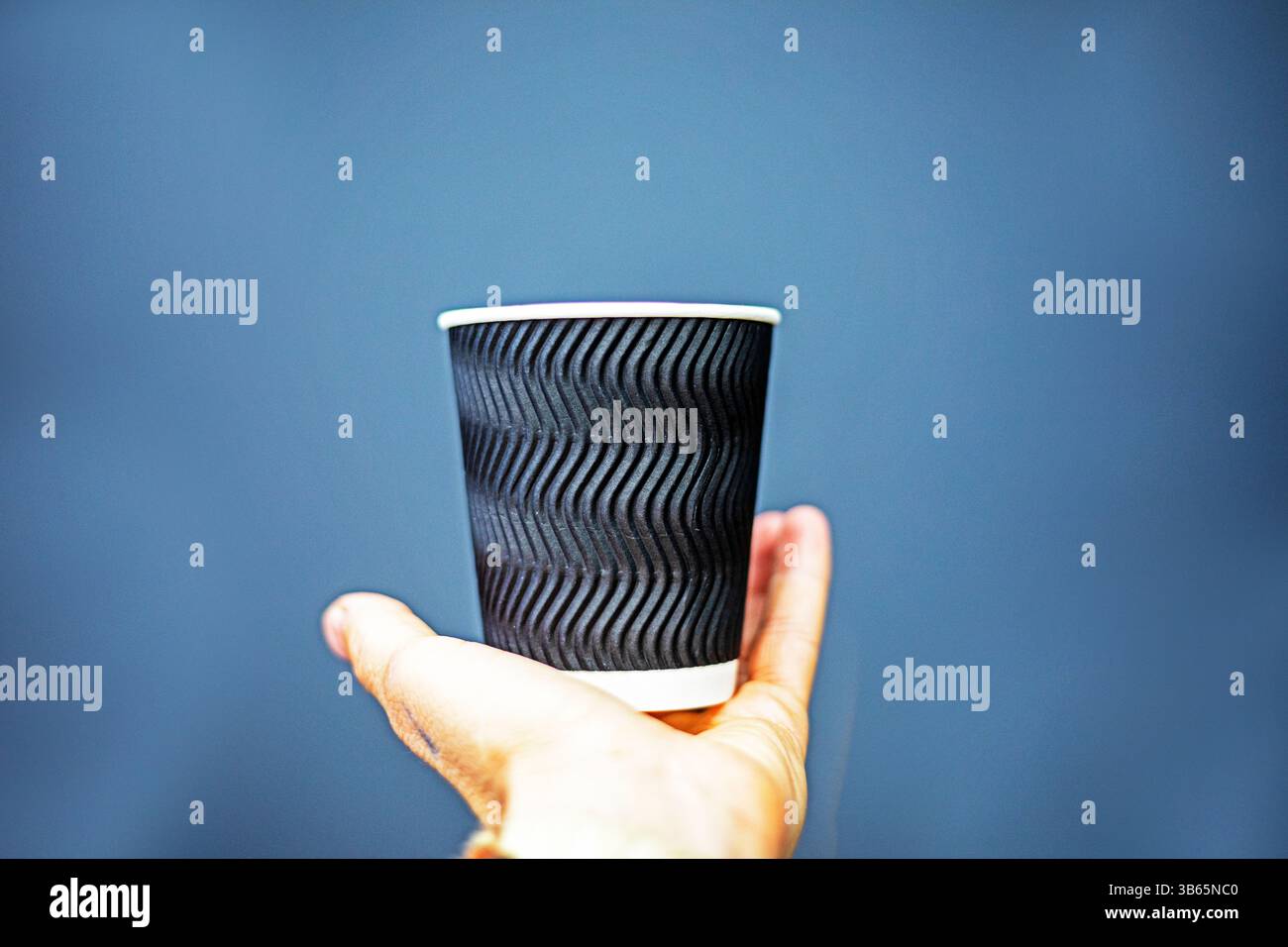 tazza monouso in rilievo nera su sfondo grigio. Mockup per design, loghi, illustrazioni Foto Stock