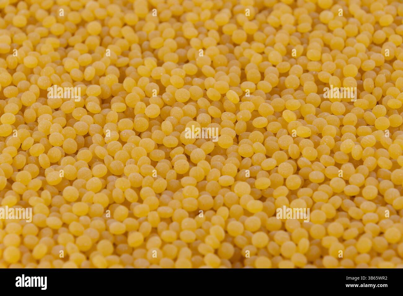 Pearl couscous. Grana fine gialla, primo piano. Background alimentare. Un punto fermo della cucina mediorientale e mediterranea. Foto Stock