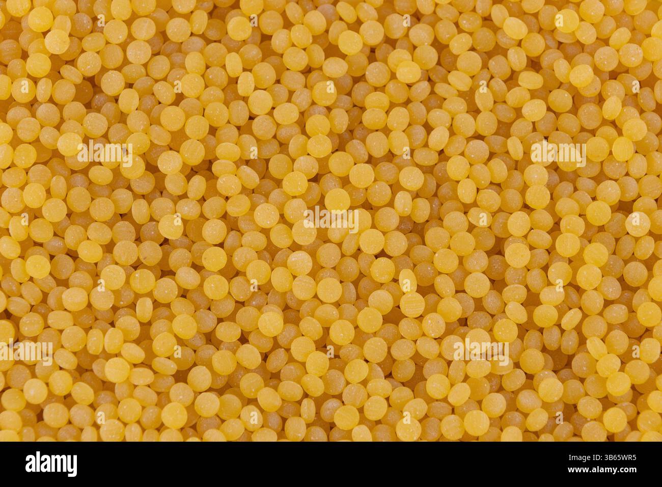 Pearl couscous. Grana fine gialla, primo piano. Background alimentare. Un punto fermo della cucina mediorientale e mediterranea. Foto Stock