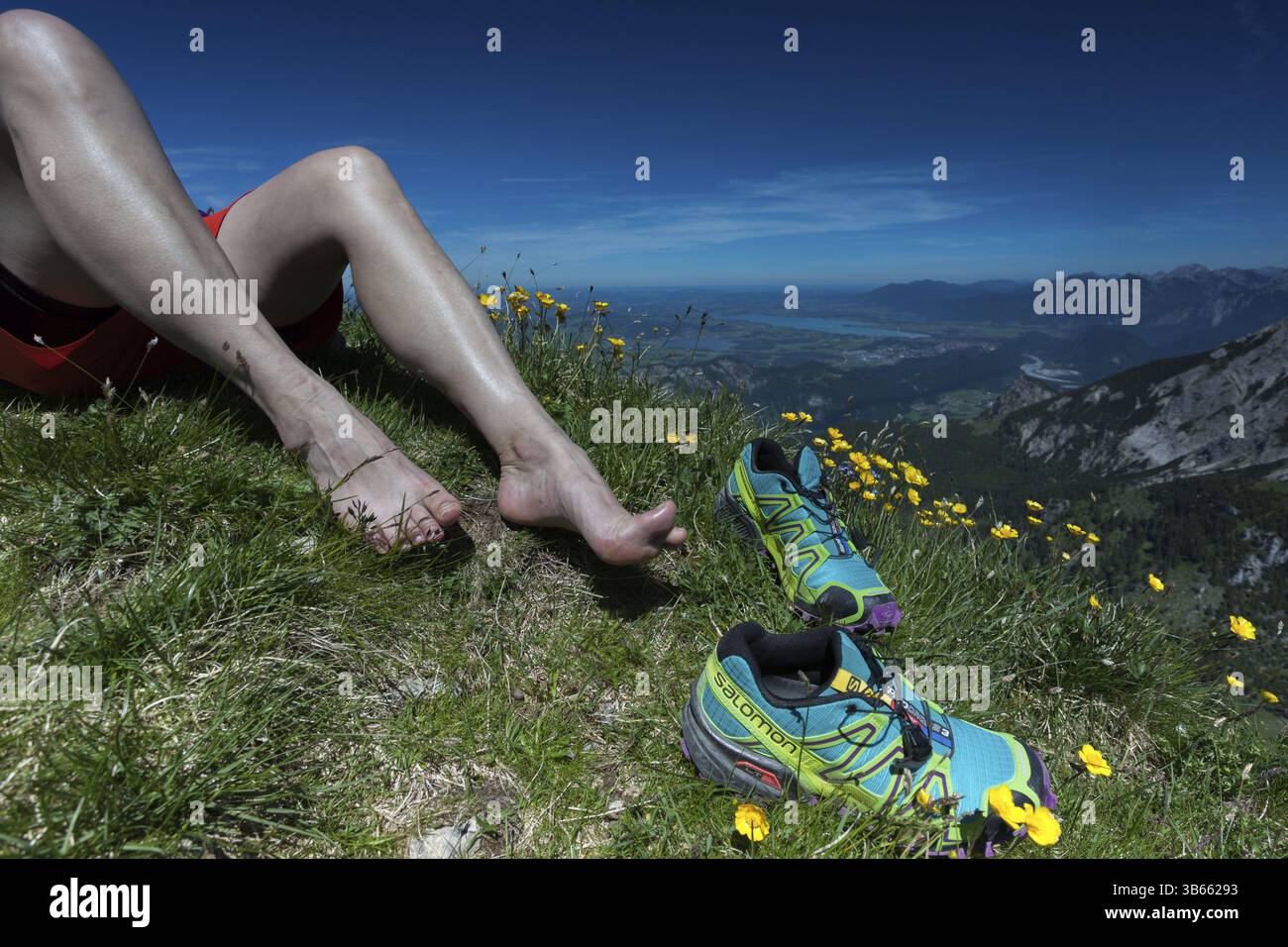 Piedi rilassati accanto agli scarponi da trekking con una vista mozzafiato sulle colline alpine, Tannheimer Berge, Allgaeu Alps, Baviera, Germania, Europa Foto Stock
