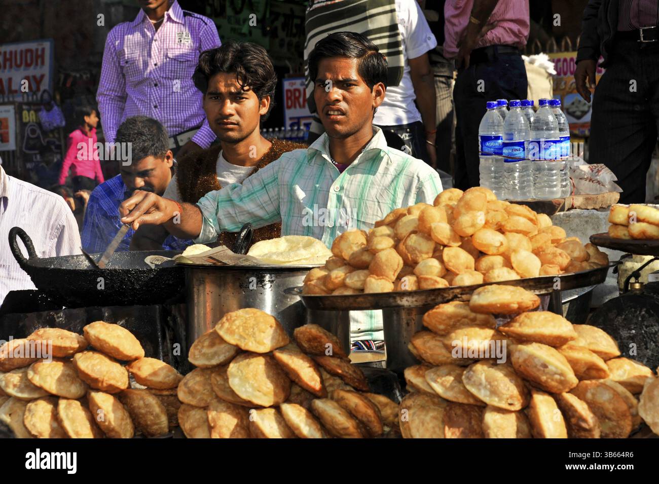 Jaipur, Rajasthan, India settentrionale, India, Asia, uomini che vendono puri in un affollato chiosco di strada in un mercato indiano, in Asia Foto Stock