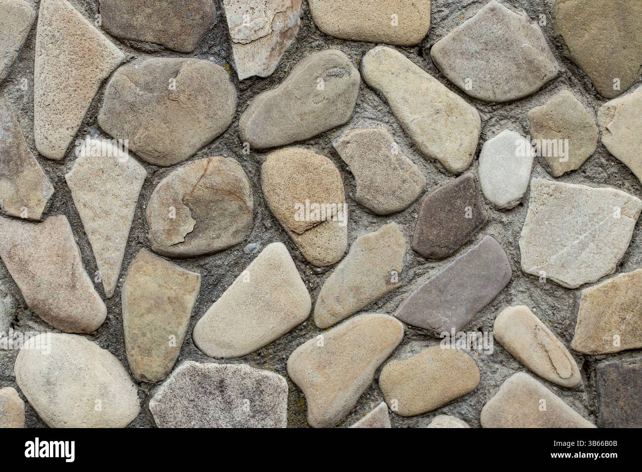 Parete in pietra di fiume con struttura in cemento, mosaico decorativo in pietra, messa a fuoco morbida Foto Stock Parete in pietra di fiume con struttura in cemento, mosaico decorativo in pietra, messa a fuoco morbida Foto Stock
