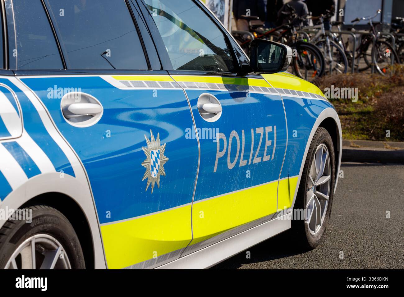 Norimberga, Germania, 2025 marzo 02: Primo piano di un'auto della polizia tedesca con strisce blu, gialle e bianche, la parola "Polizei", una maniglia della portiera e una Foto Stock Norimberga, Germania, 2025 marzo 02: Primo piano di un'auto della polizia tedesca con strisce blu, gialle e bianche, la parola "Polizei", una maniglia della portiera e una Foto Stock