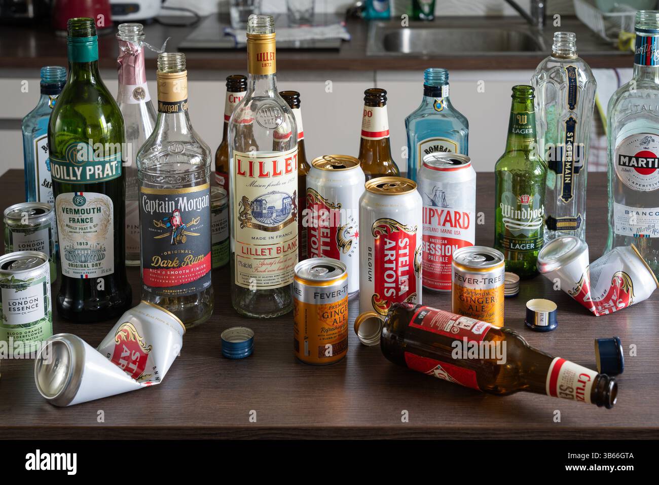 Lattine di birra vuote e bottiglie di alcolici su una cucina, in Inghilterra. Concetto: Alcolismo funzionante, alcolismo, dipendenza, scelte di vita, stile di vita, alcol Foto Stock