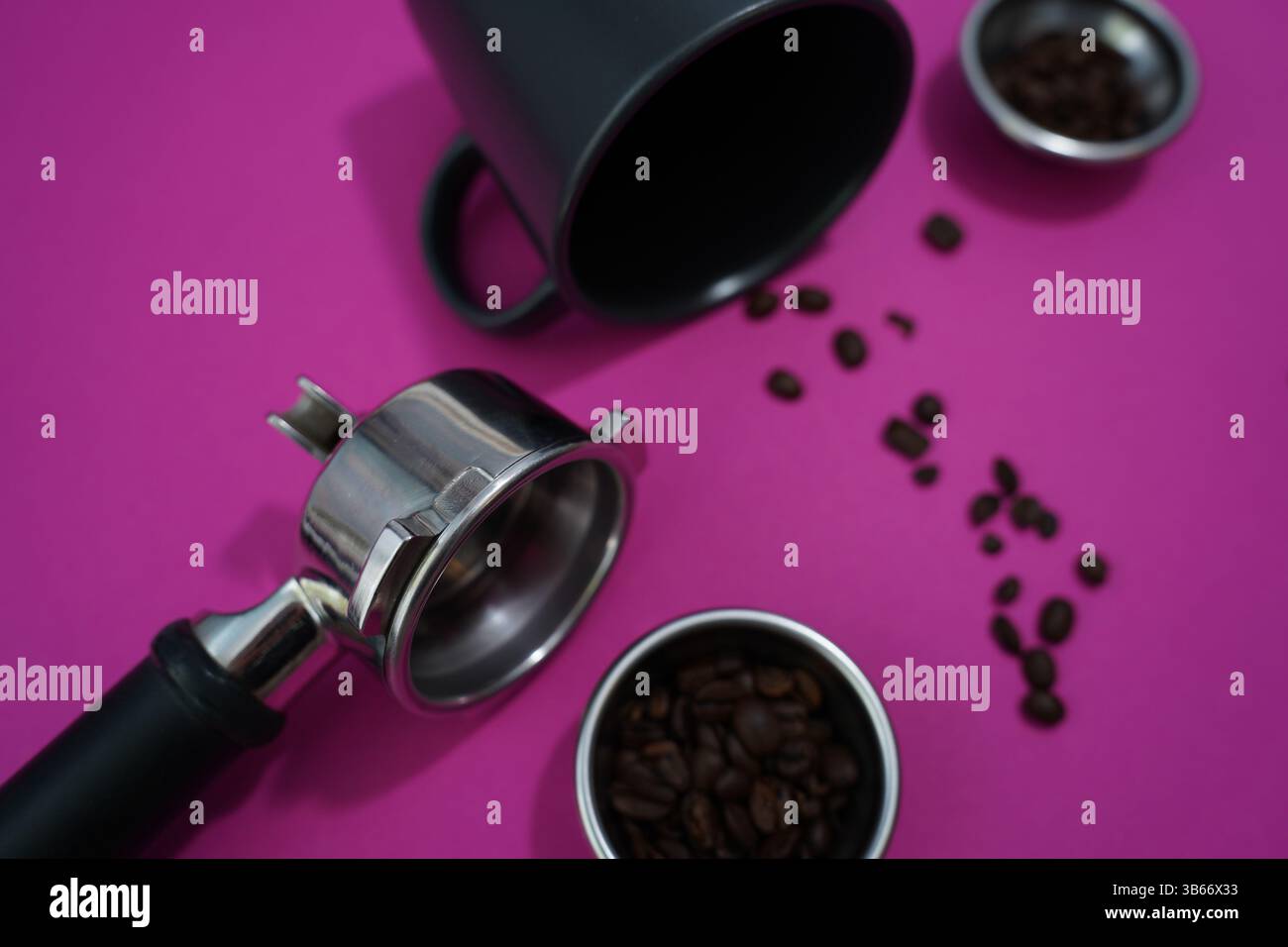 Portafiltro, chicchi e strumenti per baristi su sfondo rosa brillante: La configurazione perfetta per gli amanti dell'espresso e le caffetterie. Foto Stock
