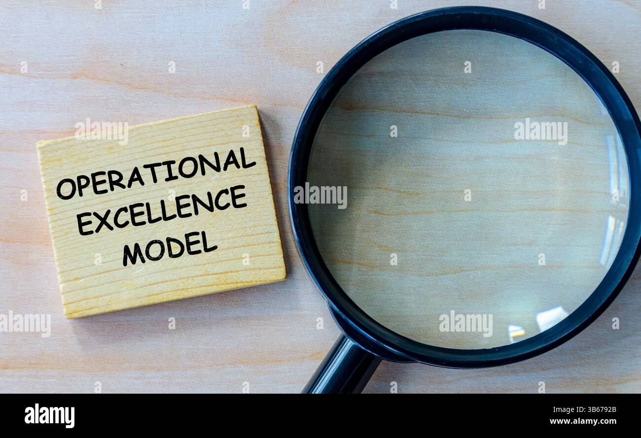 Testo del modello Operational Excellence su blocco di legno con lente d'ingrandimento Foto Stock