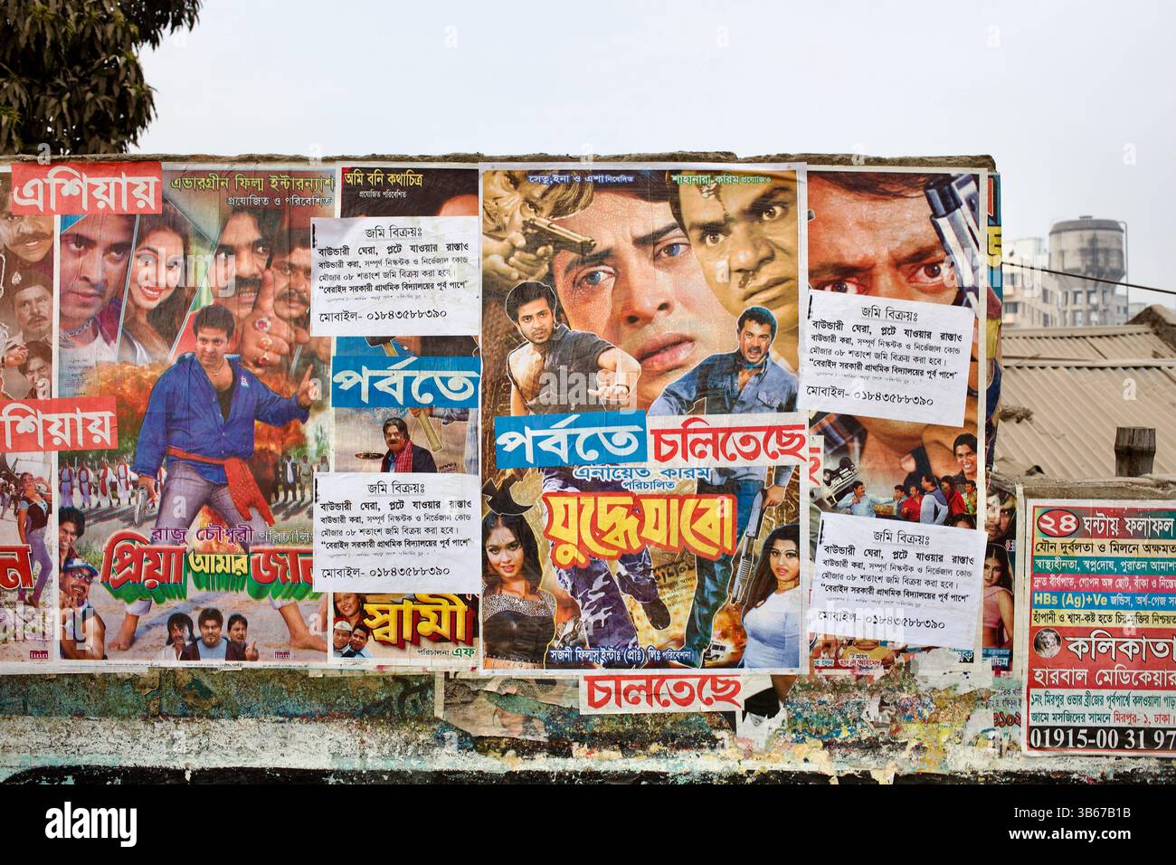 Muro di Dacca ricoperto da audaci poster cinematografici di Dhallywood, che riflettono lo spettacolo urbano e la promozione del cinema di base. Foto Stock
