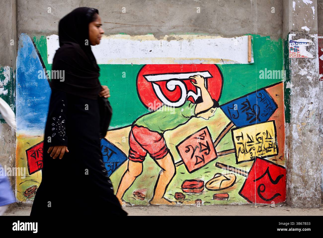 Una donna in nero passa un murale del movimento linguistico a Chittagong, dove la grafica codificata dagli uomini continua a dominare la rappresentazione della lotta nazionale. Foto Stock