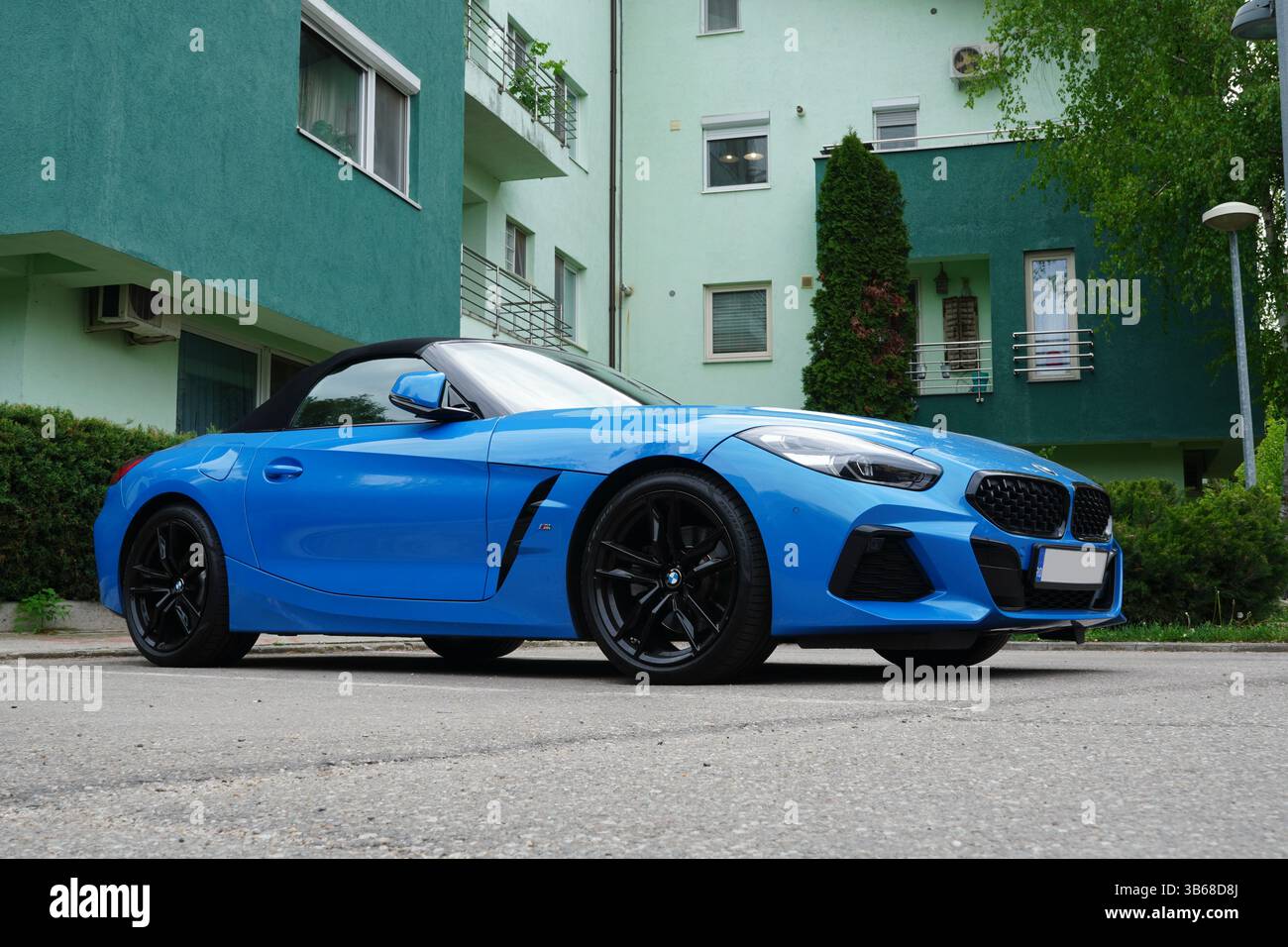Bucarest, Romania – 27 aprile 2025: Vista frontale della cabriolet BMW Z4, auto blu parcheggiata vicino al blocco di appartamenti Foto Stock