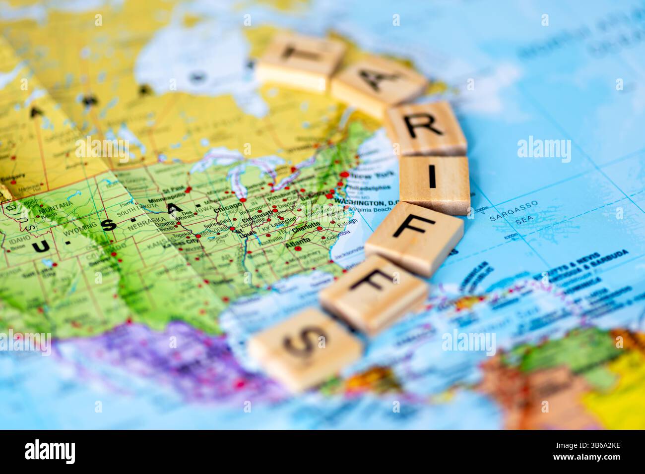 Una mappa degli Stati Uniti d'America con piastrelle di legno a lettere che formano la parola tariffe. Un concetto di tariffe USA. Foto Stock