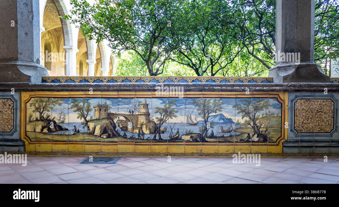 Un murale decorativo piastrellato che raffigura un paesaggio sereno con alberi, acqua e montagne lontane. Il murale presenta design complessi e colori vivaci Foto Stock