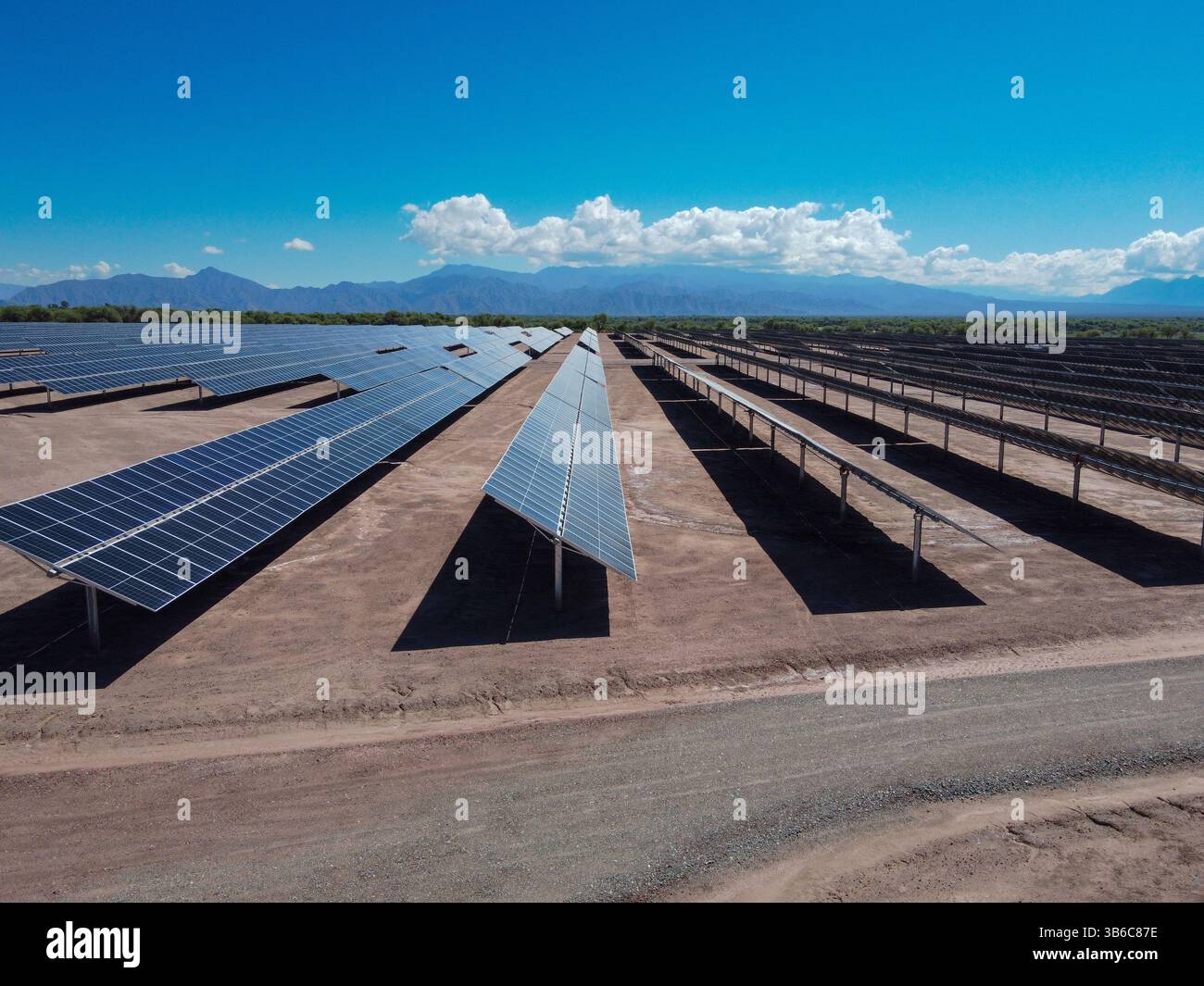 Con un cielo limpido o parzialmente nuvoloso, i campi di energia solare di Tinogasta si estendono verso le imponenti Montagne delle Ande. Un paesaggio che unisce touris Foto Stock