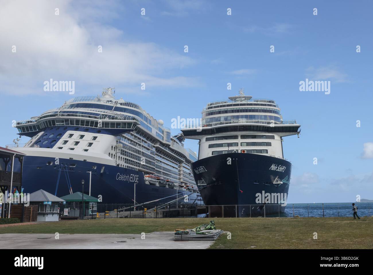 9 marzo 2022, Tortola, Isole Vergini: Uno scolaro corre attraverso un campo di fronte alle navi da crociera Celebrity Edge e TUIÃs Mein Schiff 2 nel porto di Tortola, Isole Vergini britanniche il 9 marzo 2022. L'isola ha riaperto agli ospiti nel dicembre 2020, pur mantenendo rigorosi protocolli COVID. (Immagine di credito: © Christopher Drost/SHIFT digital tramite ZUMA Press Wire) Foto Stock