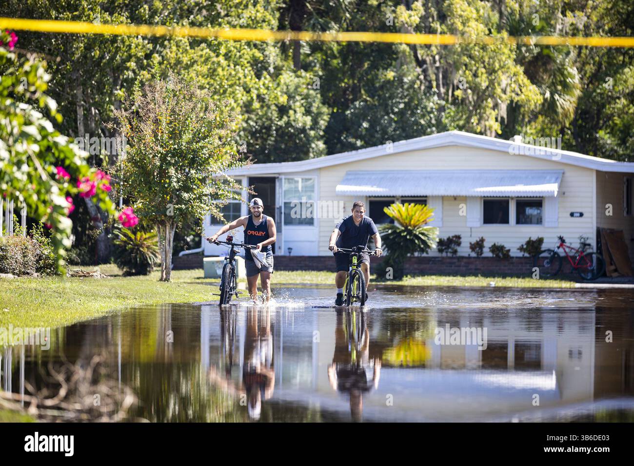 2 ottobre 2022, Winter Springs, Florida, USA: Le persone pedalano attraverso le strade allagate di Hacienda Village, una comunità di oltre 55 case fabbricate a Winter Springs, Florida, domenica 2 ottobre 2022. (Immagine di credito: © Patrick Connolly/Orlando Sentinel tramite ZUMA Press Wire) Foto Stock