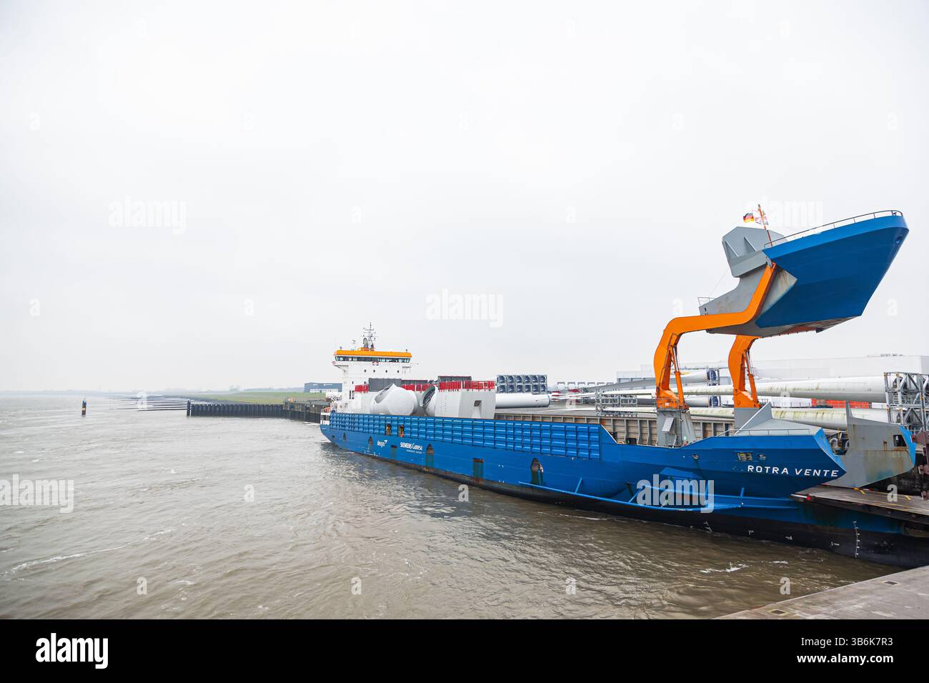 Scaricando parti delle turbine eoliche Vestas nel porto di Cuxhaven, in Germania, da una nave da carico. Foto Stock