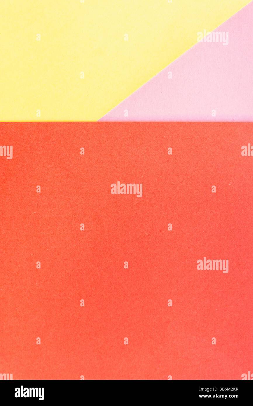 Composizione geometrica minimalista che crea uno sfondo astratto con fogli di carta colorati in rosso, rosa e giallo Foto Stock