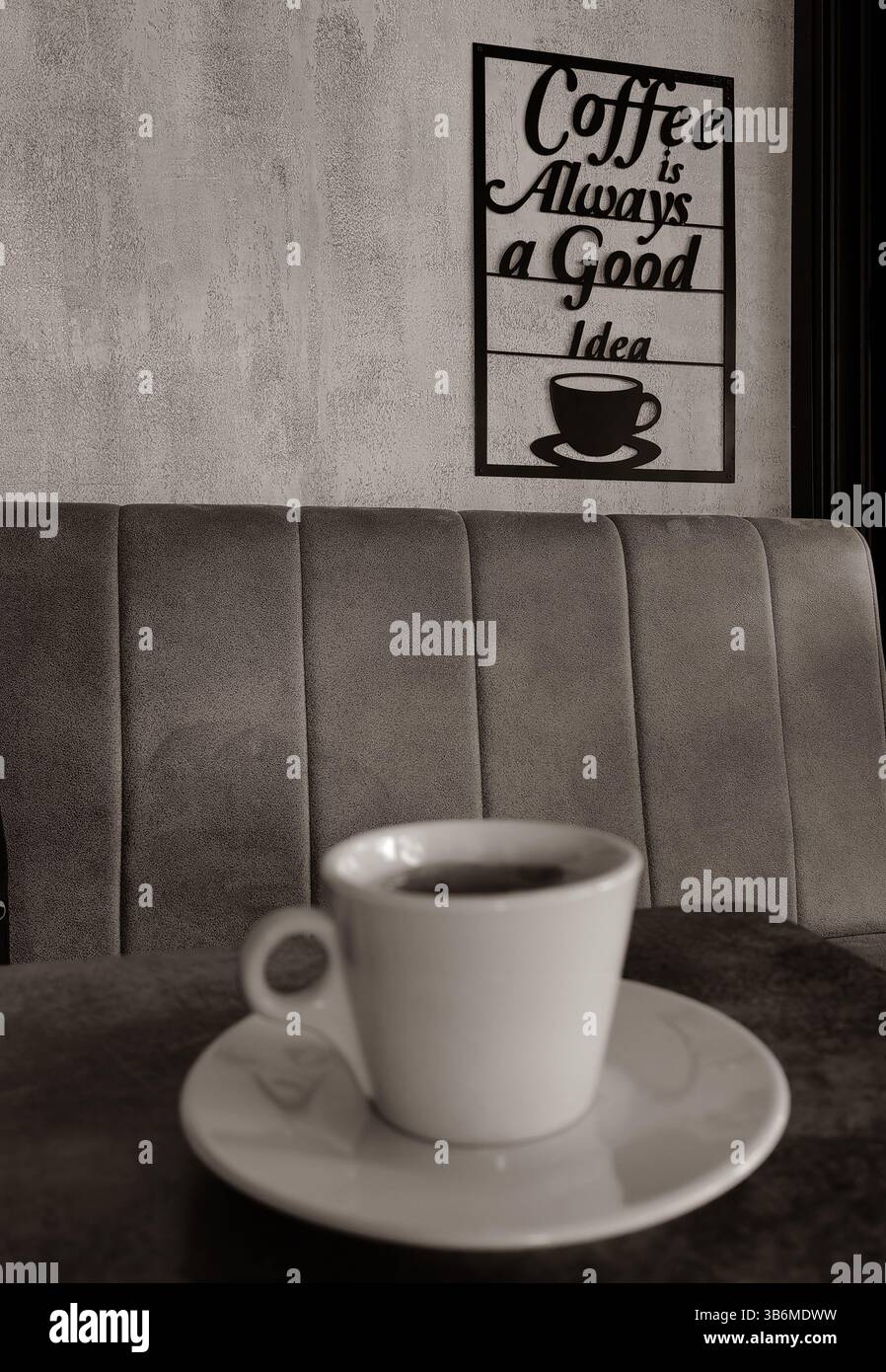 Erogazione confortevole. Il caffè è sempre una buona idea, segnaletica sull'interno grigio della parete. Lettere nere. Tazza bianca sfocata. Foto Stock