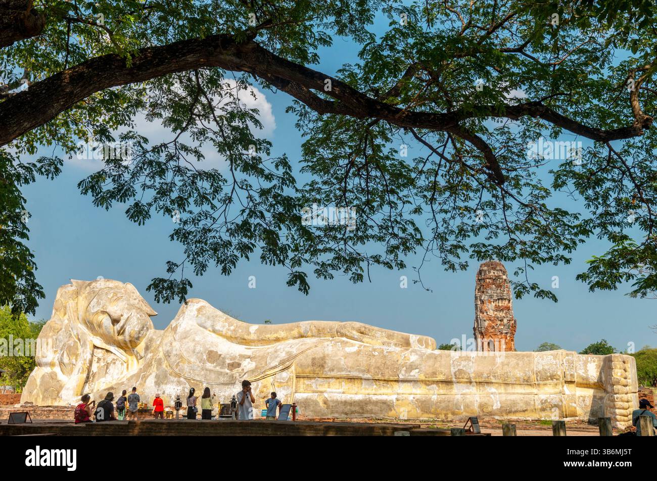 Thailandia - 9 febbraio 2024: Al Wat Lokayasutharam, al sole del pomeriggio, l'enorme statua di pietra si trova in posizione, una popolare destinazione turistica, nell'ex Siam Foto Stock