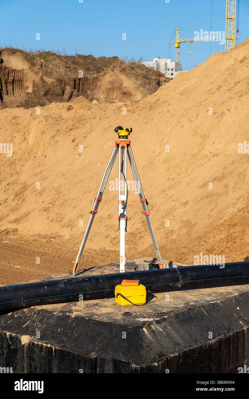 Attrezzature da topografo in un cantiere autostradale. Apparecchiature per il trasporto di teodolite in cantieri edili all'aperto, lavori topografici e topografici. Foto Stock