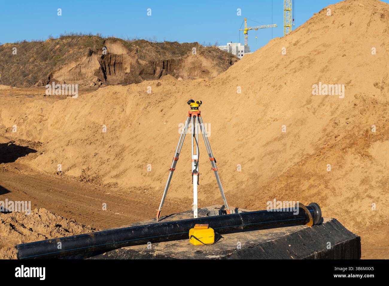 Attrezzature da topografo in un cantiere autostradale. Apparecchiature per il trasporto di teodolite in cantieri edili all'aperto, lavori topografici e topografici. Foto Stock