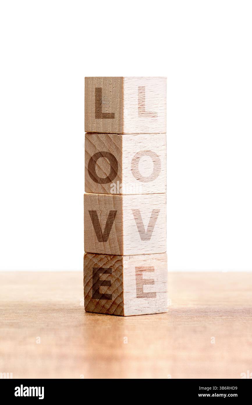 Quattro blocchi di legno sono impilati con cura, ognuno dei quali mostra le lettere della parola amore. I blocchi hanno un design minimalista e una finitura naturale, enha Foto Stock