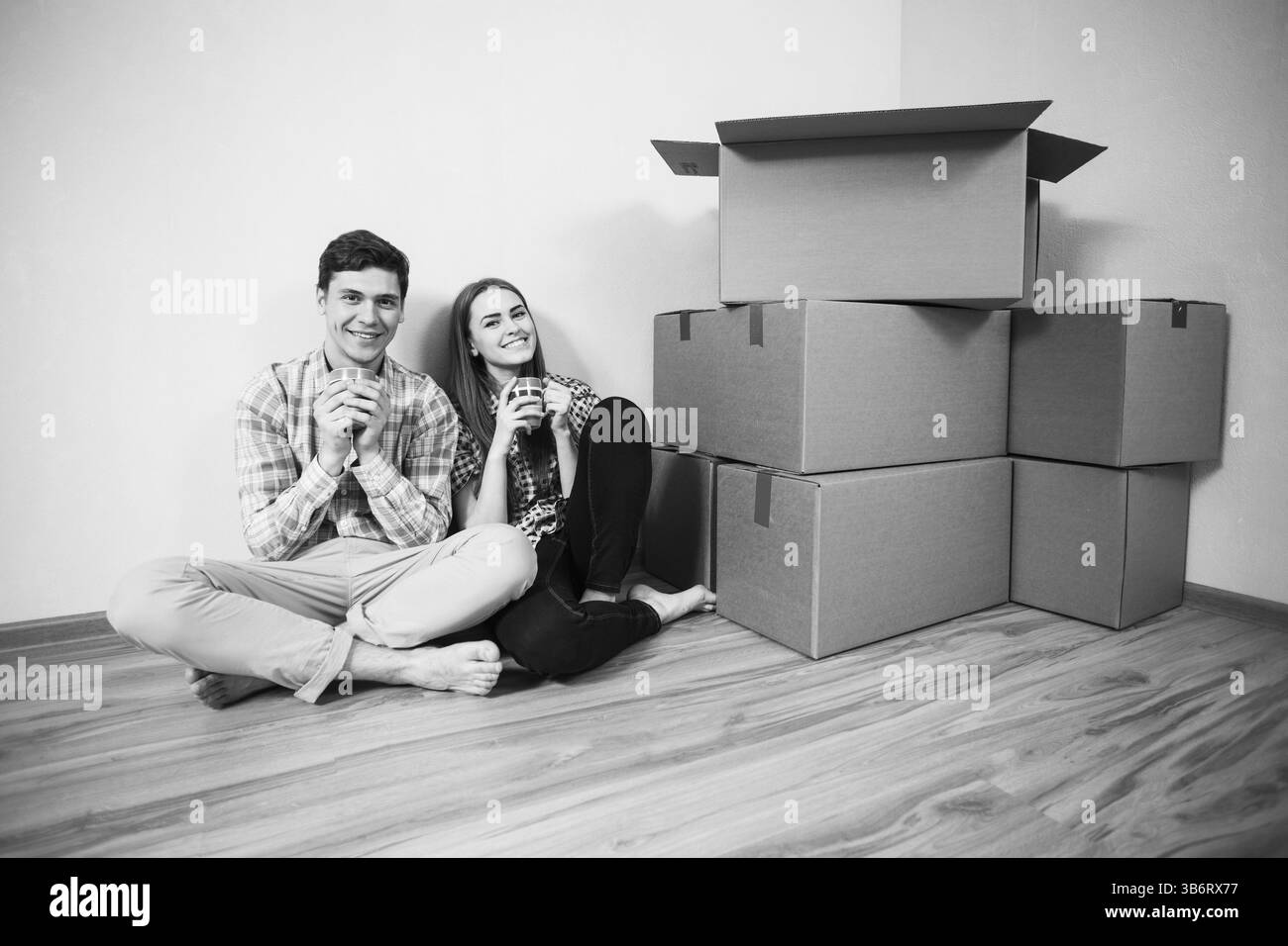 Trasferito giovane bere il tè sul pavimento Foto Stock