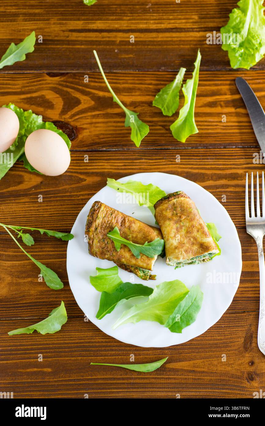 Rotolo di uova sano con verdure su un piatto bianco. Foto Stock