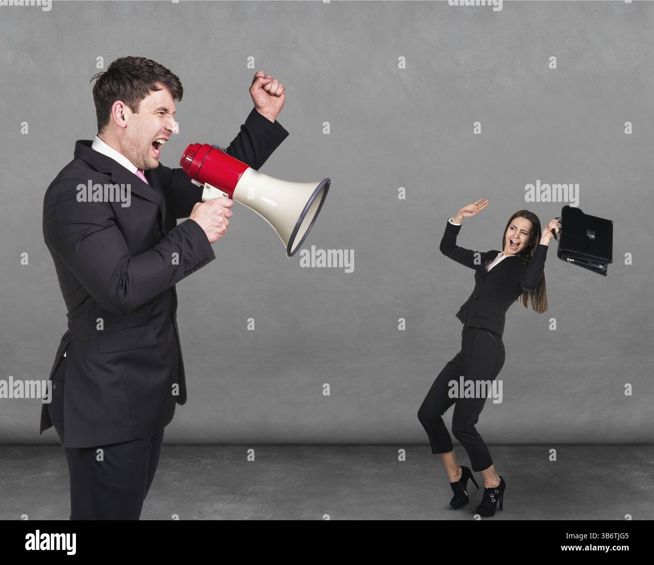 Uomo insoddisfatto che urla contro una piccola donna spaventata su sfondo scuro Foto Stock