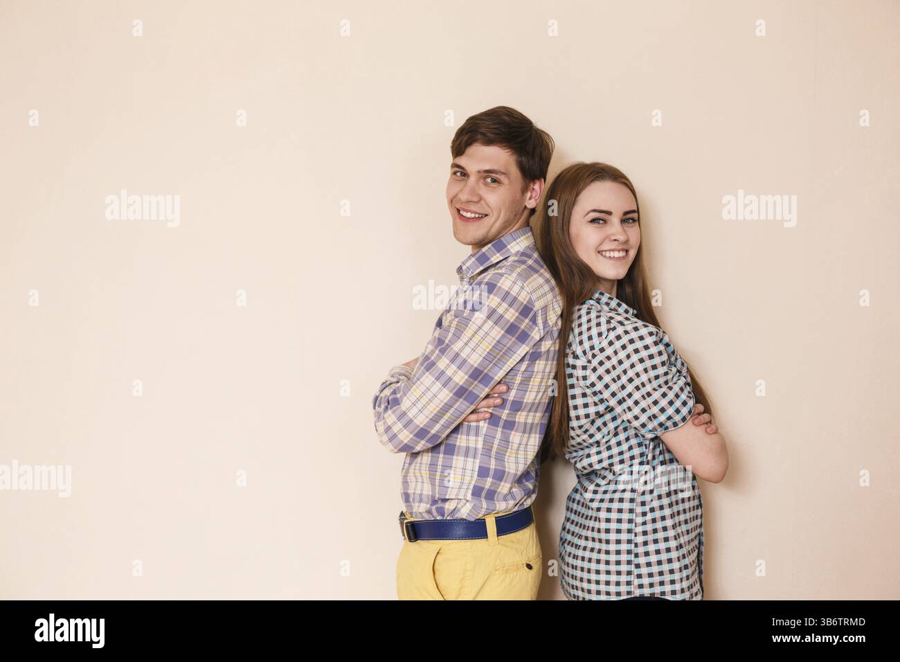 Una coppia sorridente e felice in una stanza vuota, al chiuso Foto Stock