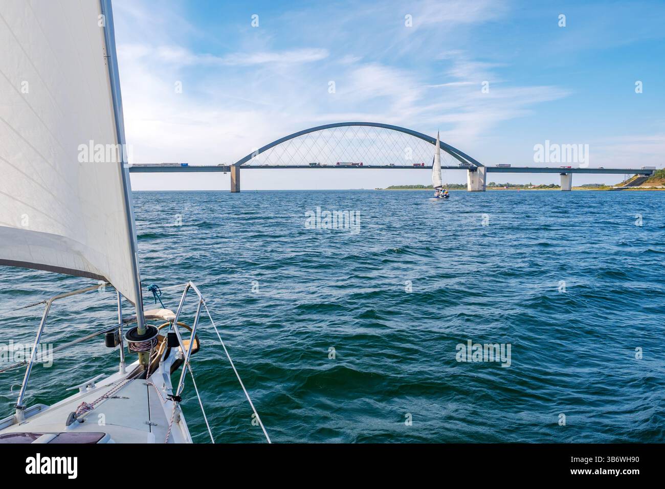 Barche a vela che attraversano il Fehmarn Sound Bridge che collega l'isola di Fehmarn con la terraferma di Schleswig-Holstein, Germania settentrionale Foto Stock