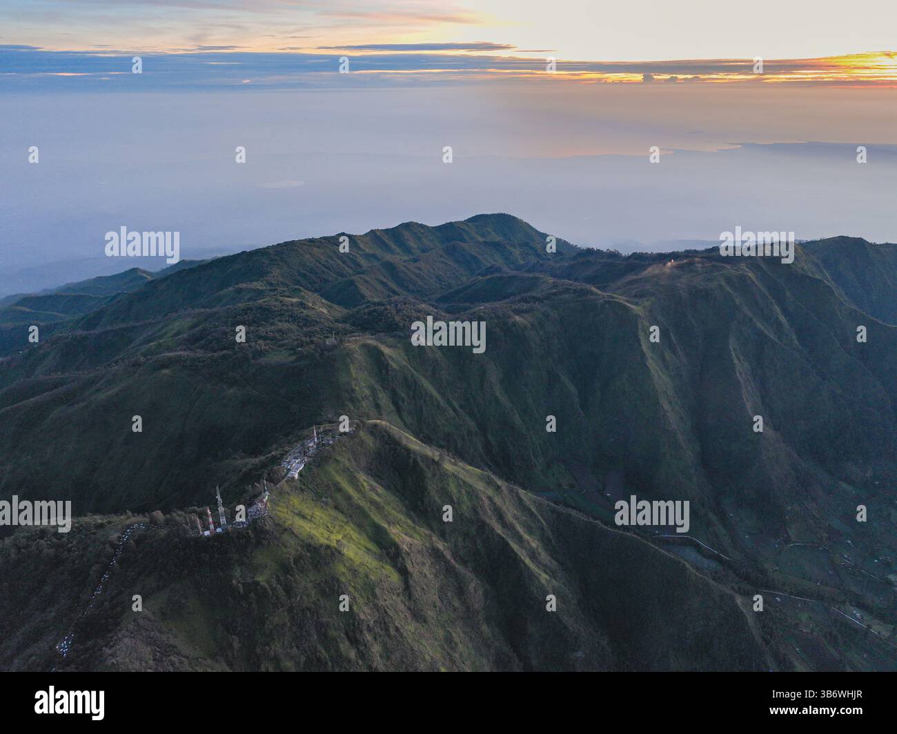 Vista aerea colorata nebbia copre la montagna in un incredibile video di tramonto Looping che mostra una splendida scena con il sole che tramonta dipingendo il cielo sopra t Foto Stock