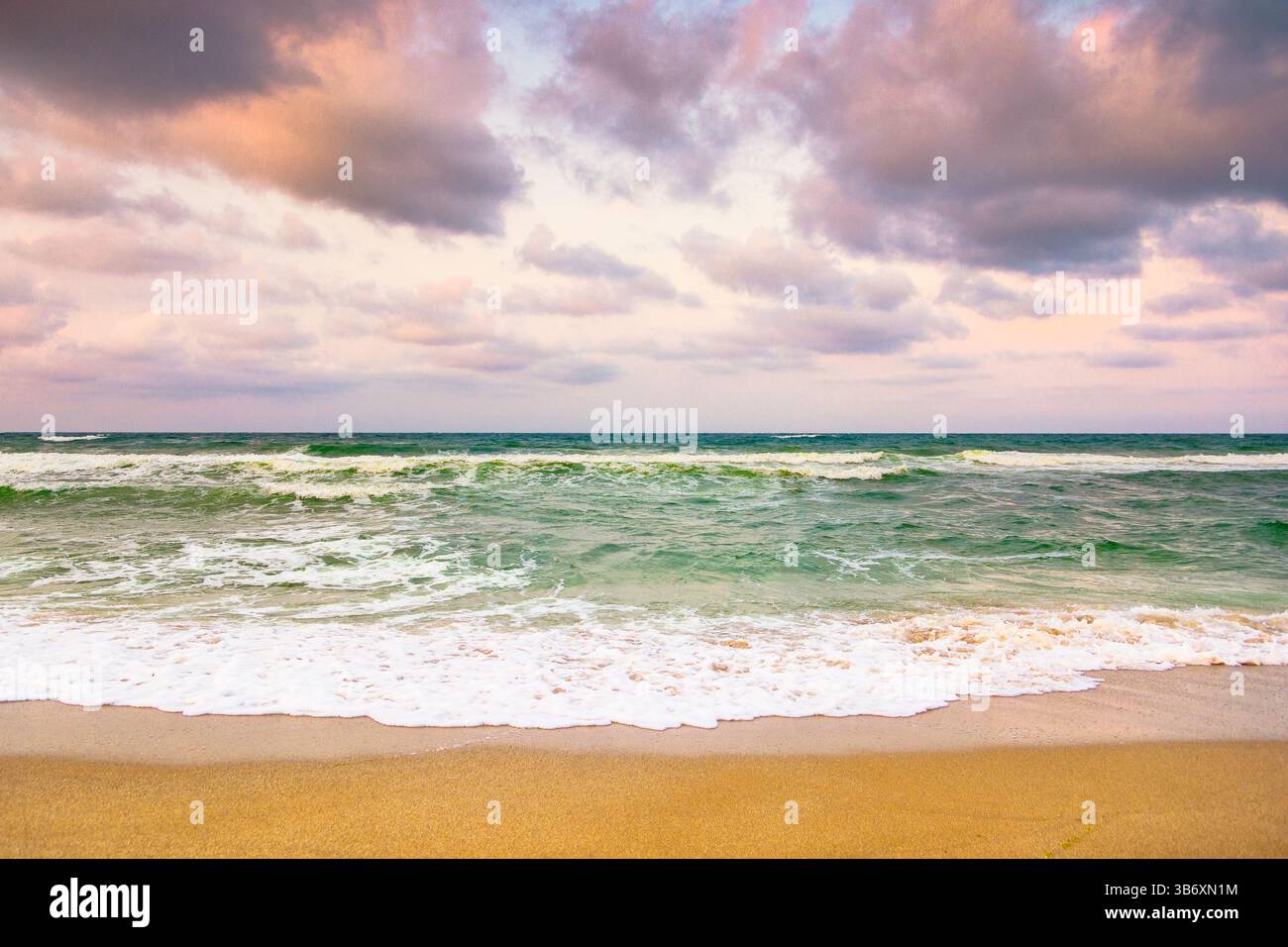 cielo sereno nuvoloso al mare nero. marea con schiuma e spruzzi. il tempo cambia in natura. bellissimo paesaggio arancione. vacanze estive spettacolari in eur Foto Stock